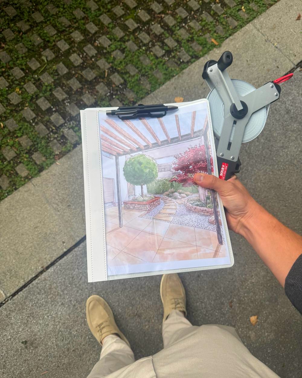 Aufmaß vor Ort mit Messrad und Entwurf in der Hand
