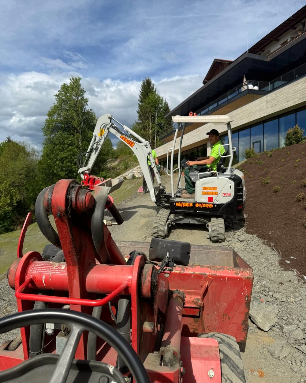Minibagger und Hoftrac bei Erdarbeiten an einem Hang